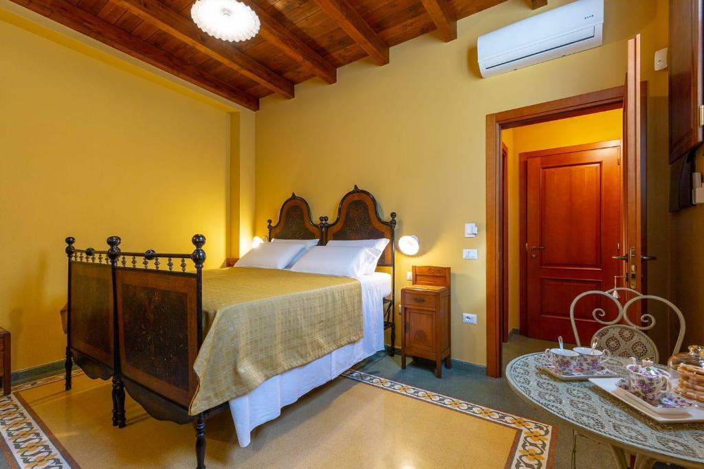 a bedroom with a large bed with a wooden headboard at B&B ANTICA KALAGONIS in Maracalagonis