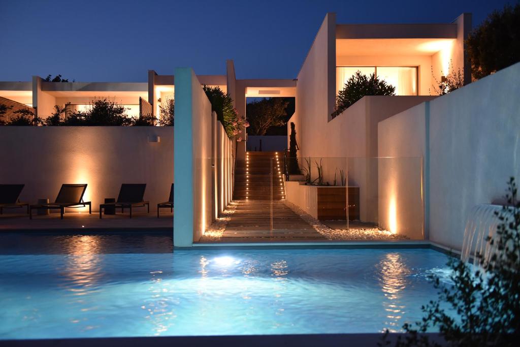 una casa con piscina por la noche en Hôtel Cala di Greco en Bonifacio