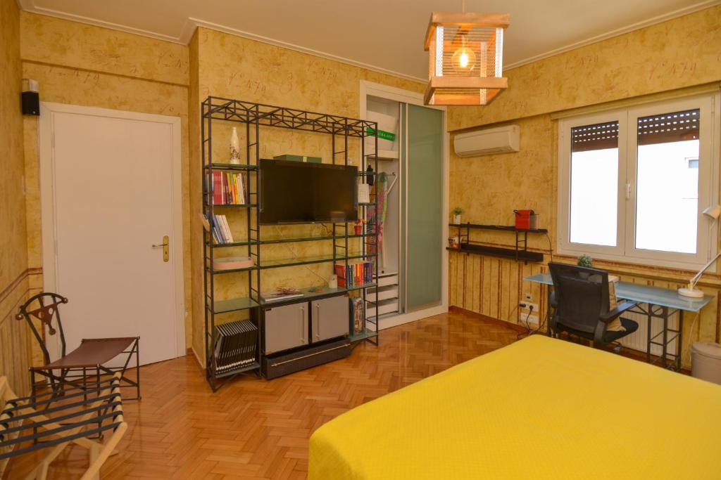 una camera con letto giallo e TV di Athens Stylish studio in front of Syntagma metro stop for 2 ad Atene