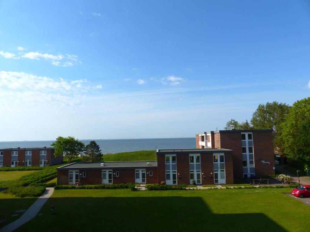a brick building with the ocean in the background at Oland Whg 13 Seestern in Wyk auf Föhr