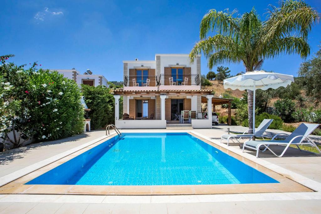 a villa with a swimming pool and a house at Villa AmberBlue Kalathos in Kalathos