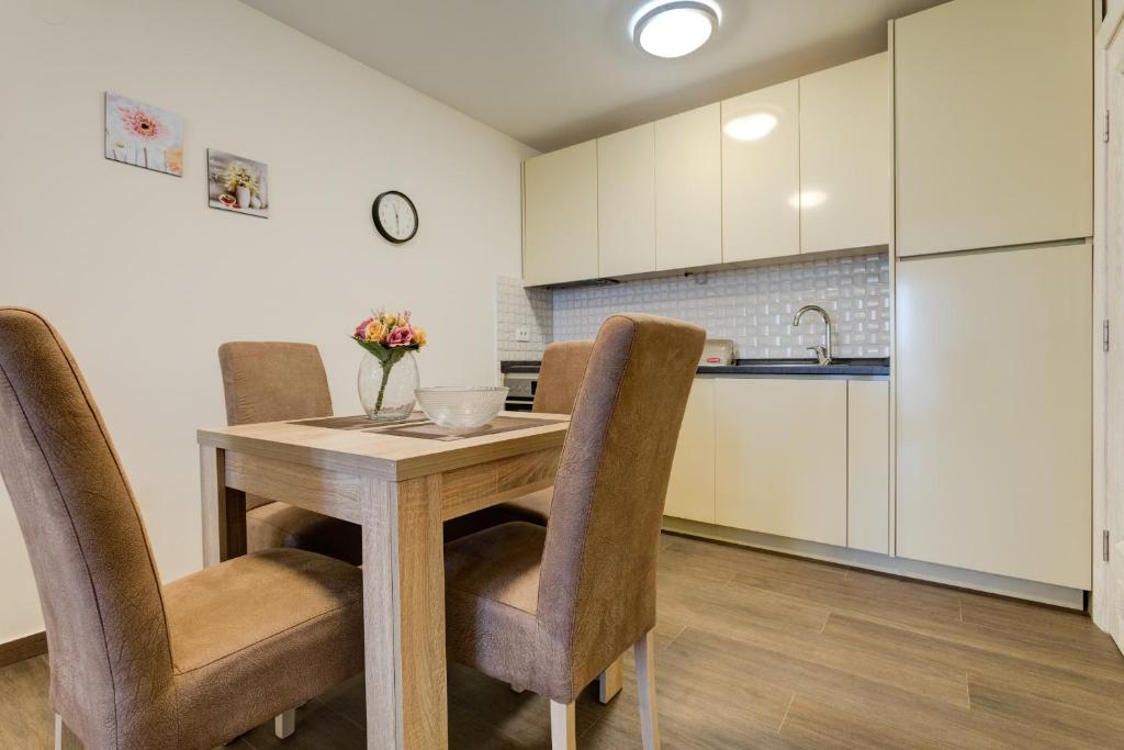 a kitchen with a wooden table and chairs at Apartments Horizont in Budva