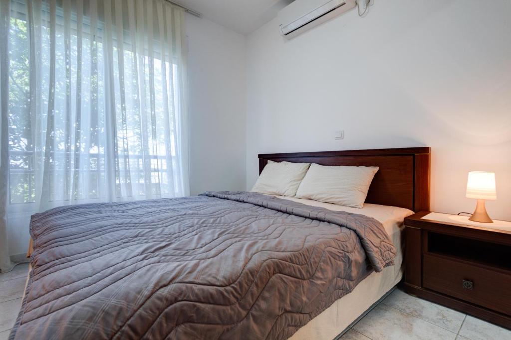 a bedroom with a large bed and a window at Apartments Horizont in Budva