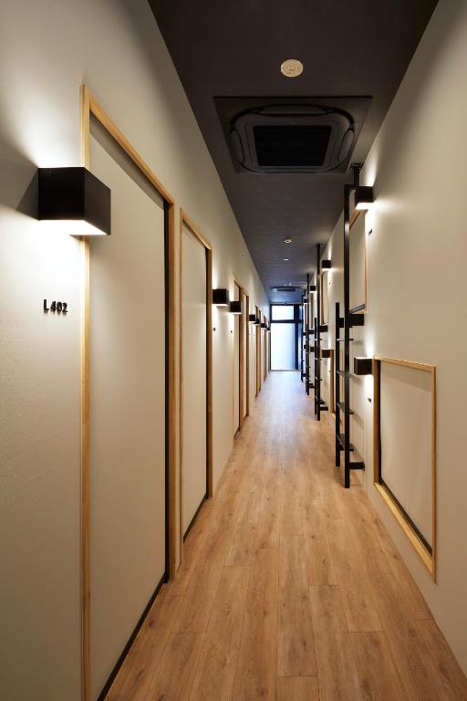 a hallway with a row of paintings on the walls at hotel atarayo osaka in Osaka