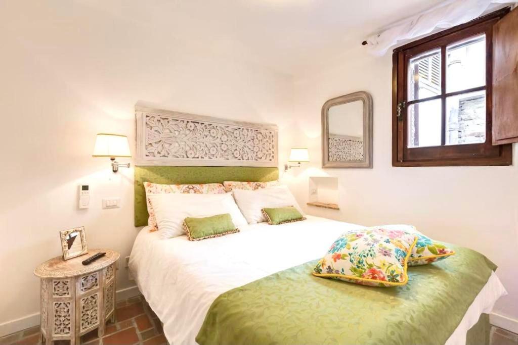 una camera da letto con un grande letto bianco e uno specchio di Cedro Home a Roma