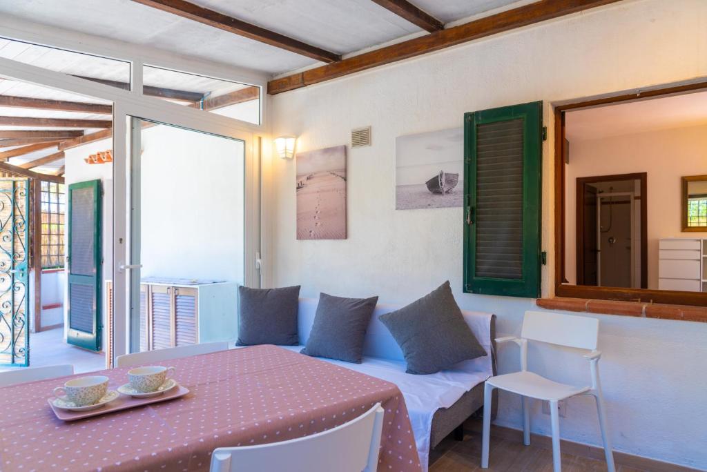 ポルトフェッラーイオにあるAppartamento A due passi dal mareのベッド、テーブル、椅子が備わる客室です。