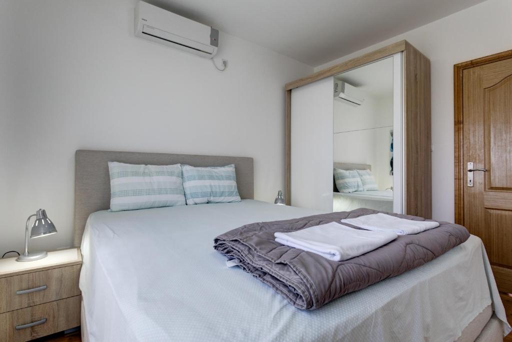 a bedroom with a bed with two towels on it at Apartments Horizont in Budva