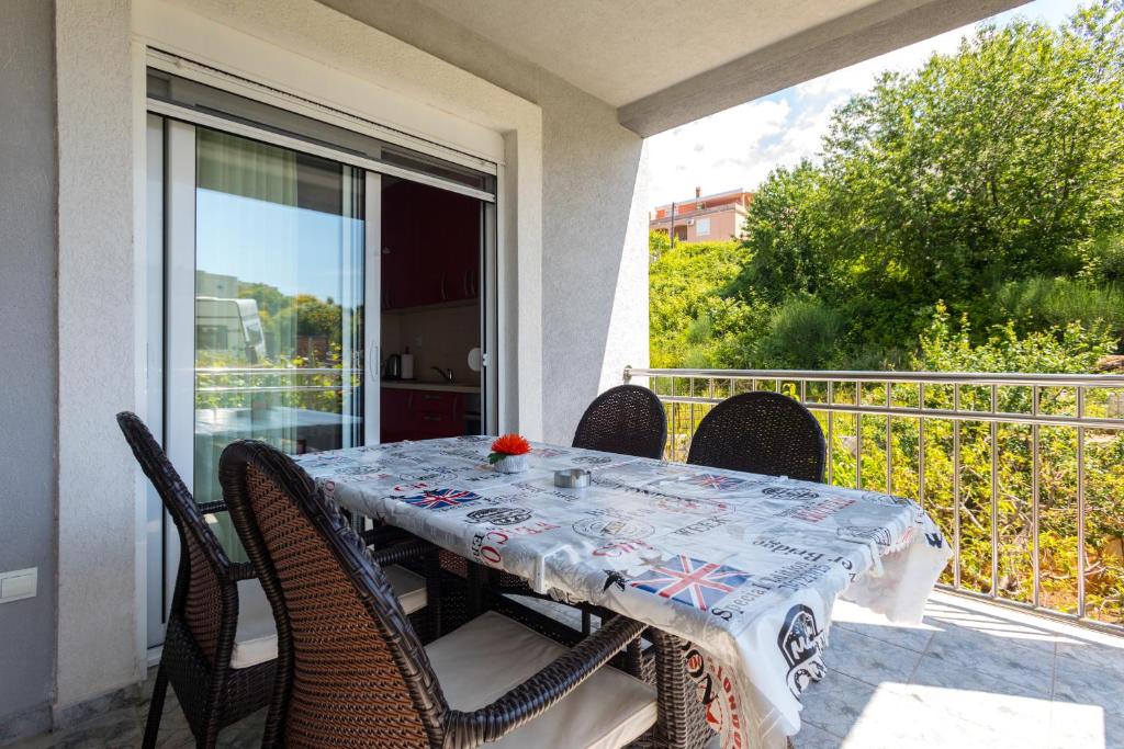 a table and chairs on a balcony with a table and a view at Apartments Horizont in Budva