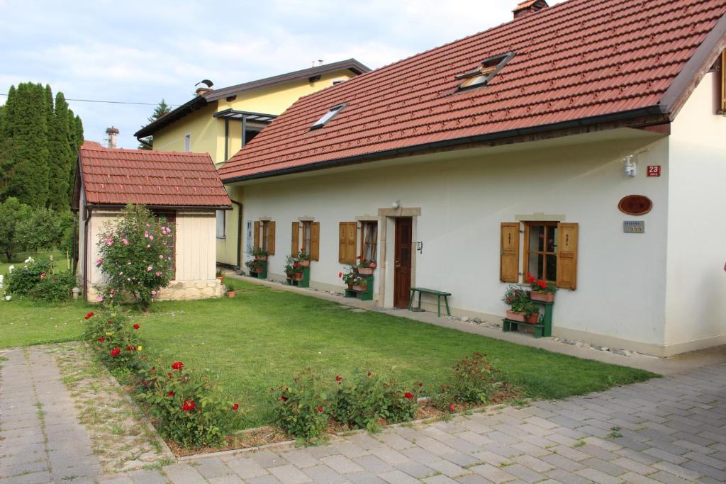 uma casa branca com um telhado vermelho e um quintal em Sleeping in Village em Svečina