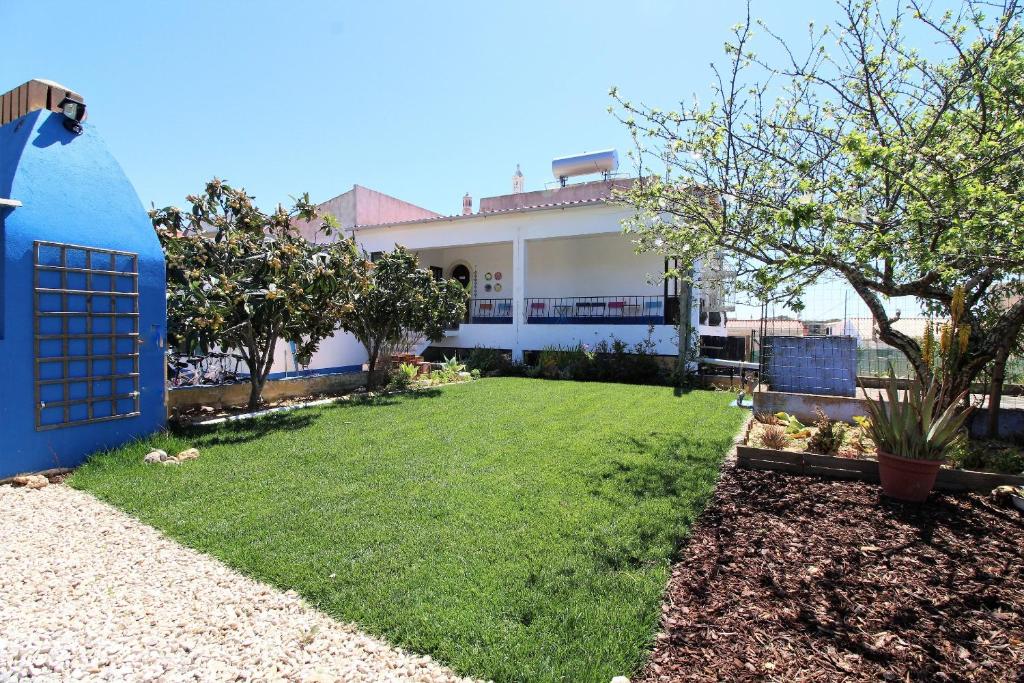 un patio con una casa con una valla azul en Quinta do Silvestre, en Albufeira