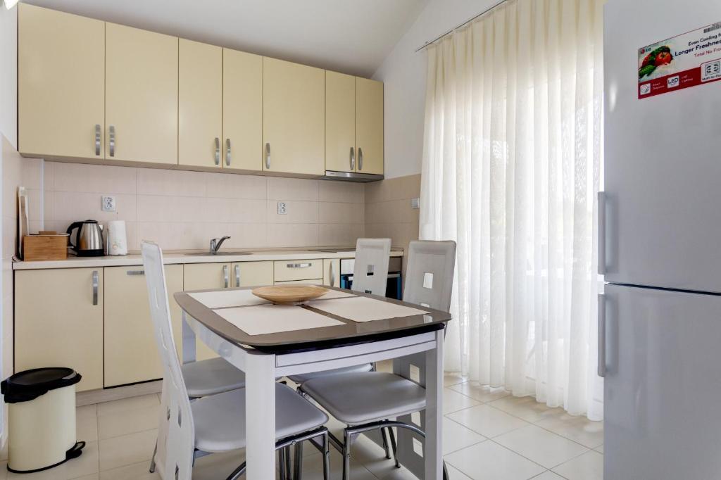 a kitchen with a table and chairs and a refrigerator at Apartments Horizont in Budva