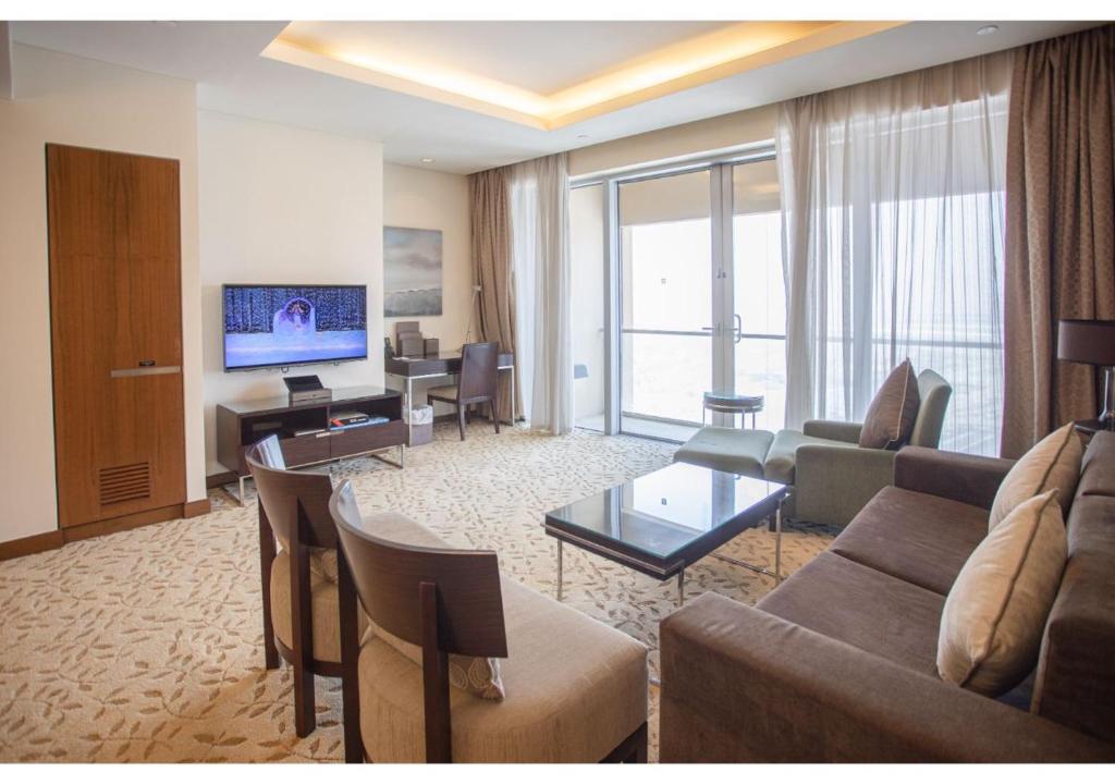 a living room with a couch and a tv at Dubai Mall Residences -Luxury 1 bedroom in Dubai