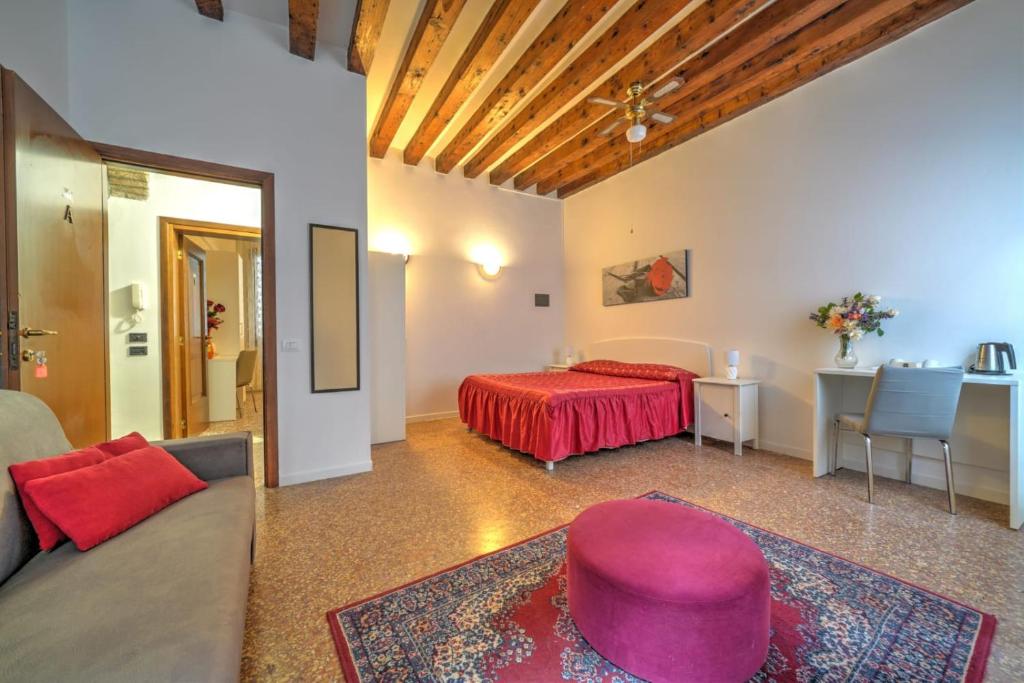 um quarto com uma cama, uma mesa e um sofá em Residenza Briati em Veneza