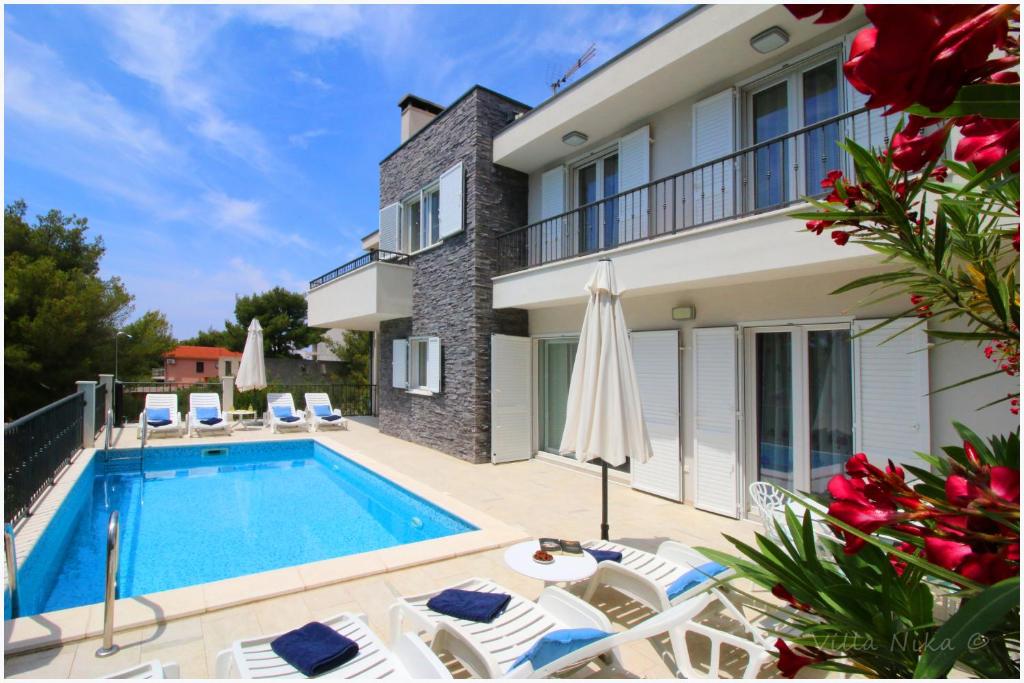 eine Villa mit einem Pool und einem Haus in der Unterkunft Apartments Nika in Primošten