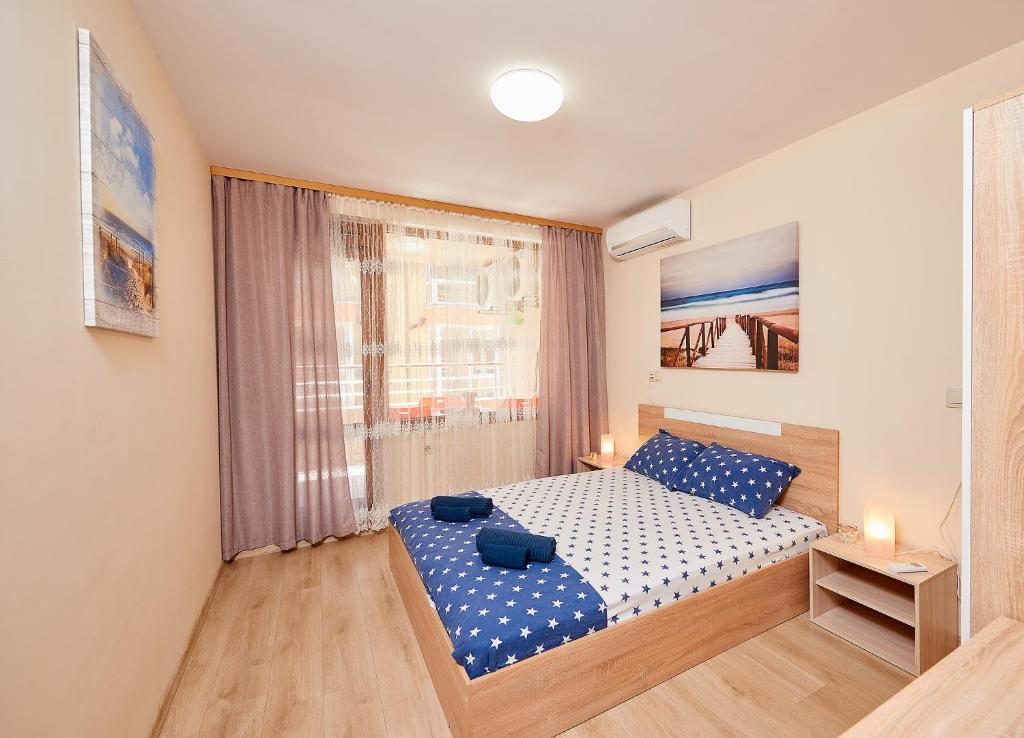 a small bedroom with a bed and a window at Апартаменти Лазур на 200м от плажа с Безплатен Паркинг in Pomorie