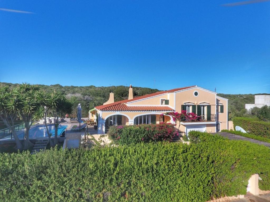 a house on a hill with a parking lot at Villa Quatre Vents in Punta Prima