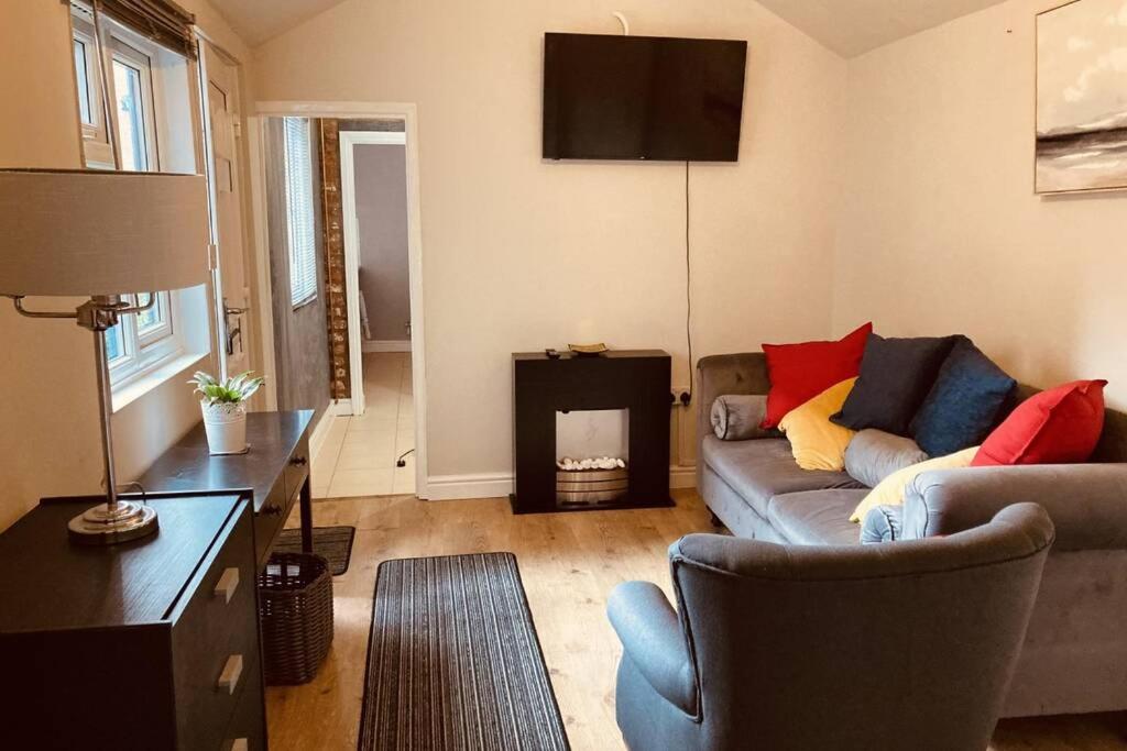 sala de estar con sofá y chimenea en 2 Beautiful Apartments in One House en Kidderminster