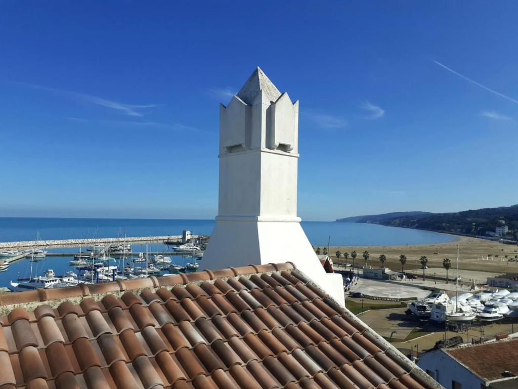 un phare sur le toit avec un port de plaisance dans l'établissement APPARTAMENTO SANTUCCI, à Rodi Garganico