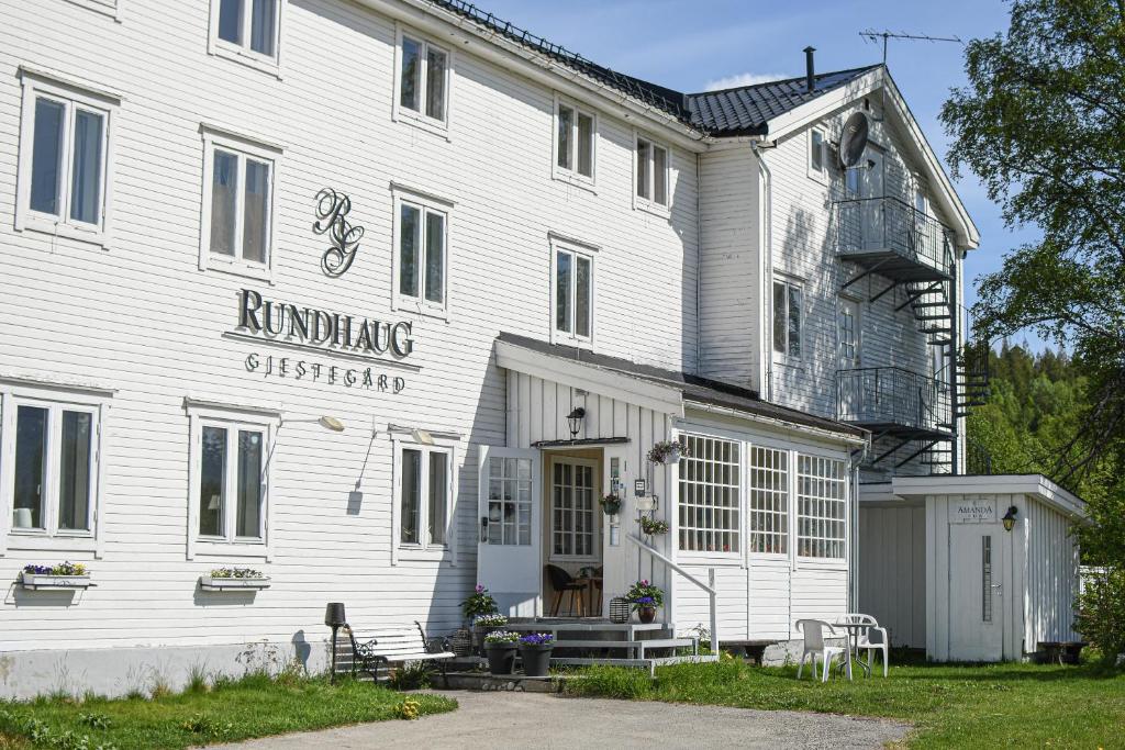 un edificio blanco con un letrero que lee tranvía corriendo en Rundhaug Gjestegard, en Rundhaug