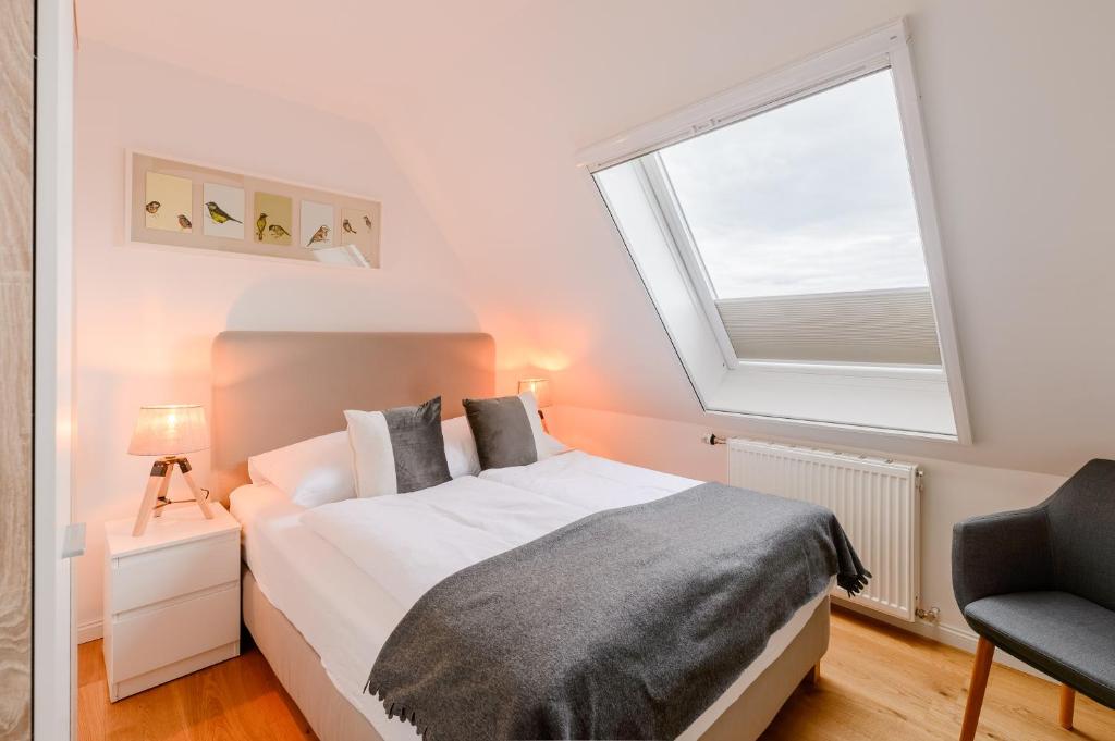 a bedroom with a bed and a large window at Strand-Muscheln in Dagebüll