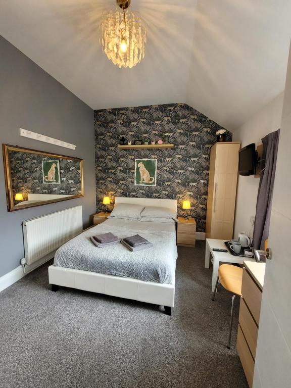 a bedroom with a white bed and a stone wall at Room@87 in Ellesmere Port