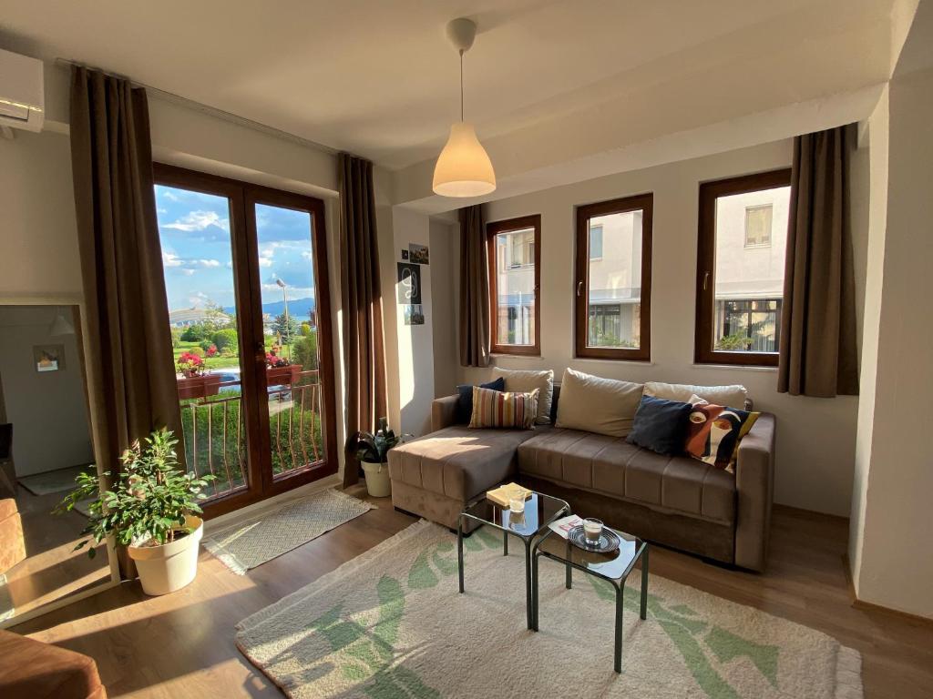 a living room with a couch and a large window at Sunset Apartment in Struga