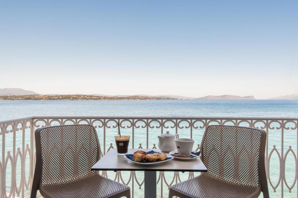 Klimis Hotel في سبيتسيس: طاولة مع صحن من الطعام و كرسيين