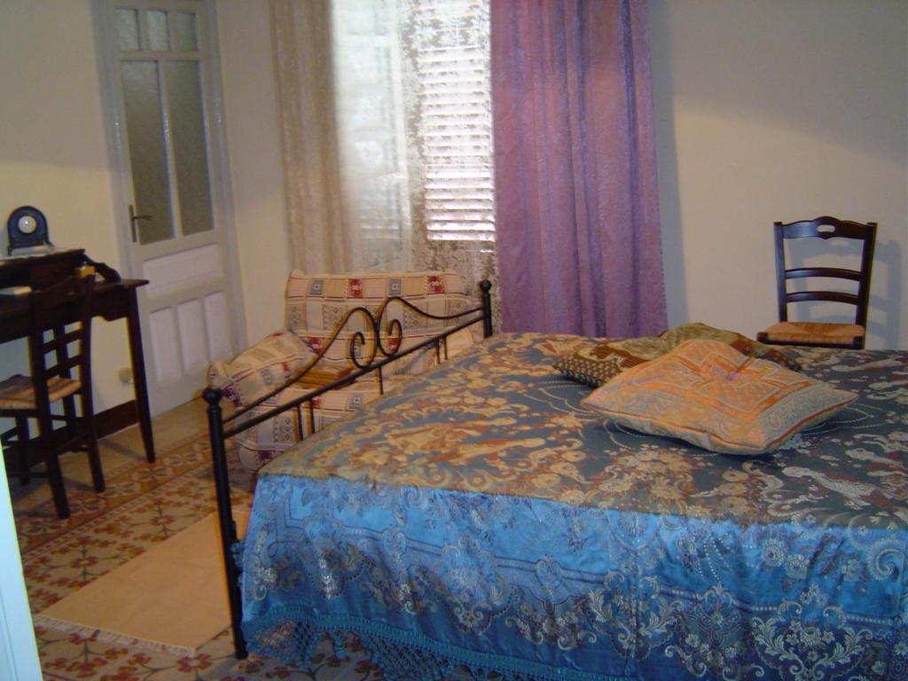 カリーニにあるVecchia Carrucolaのベッドルーム1室(ベッド1台、椅子、ピアノ付)