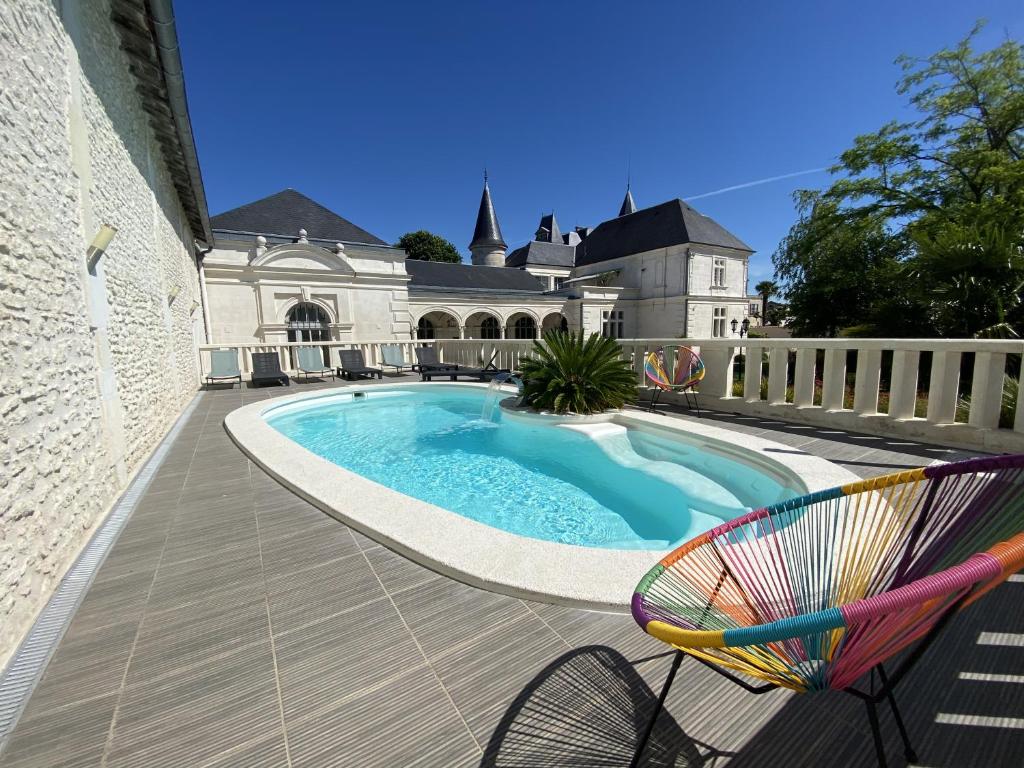 einem Pool mit einem Stuhl und einem Gebäude in der Unterkunft Château Pellisson in Cognac