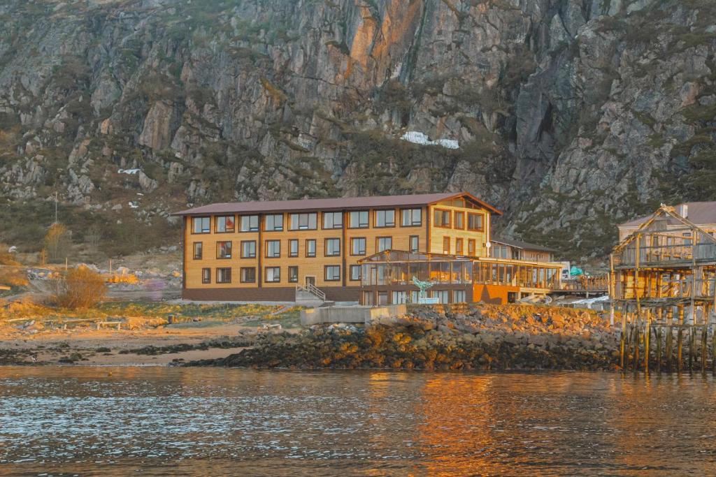 a painting of a building next to a body of water at Cedar Grass Teriberka in Teriberka