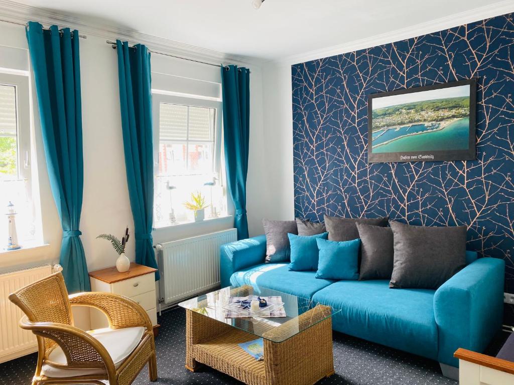 a living room with a blue couch and a table at Pension & Ferienwohnungen Schneidereit in Sassnitz