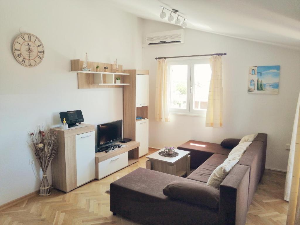 ein Wohnzimmer mit einem Sofa und einem TV in der Unterkunft Santa Marina in Vabriga