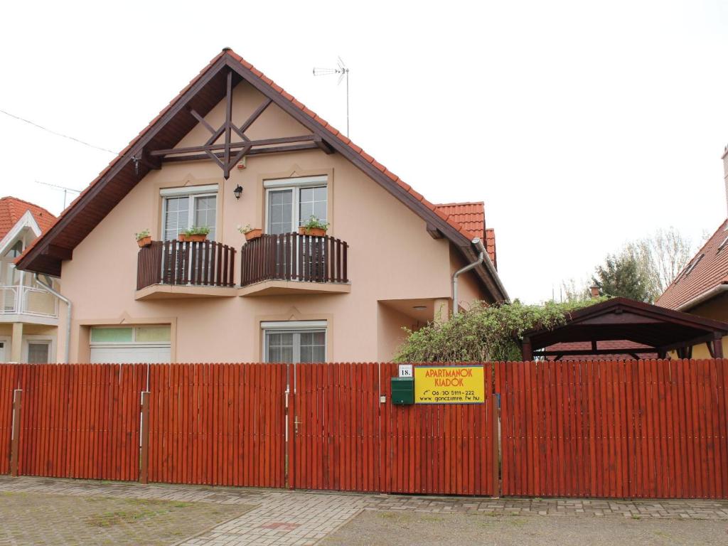 czerwony płot przed domem w obiekcie Imre Apartman w Hajduszoboszlo