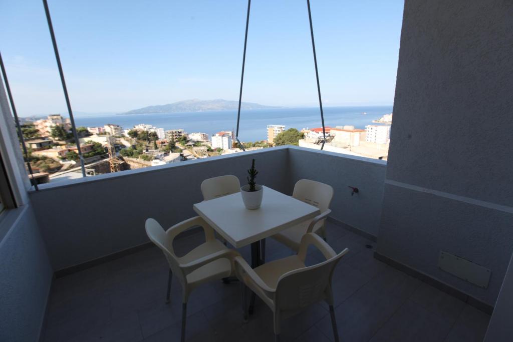 einen Tisch und Stühle auf einem Balkon mit Meerblick in der Unterkunft Mane Apartments in Sarandë