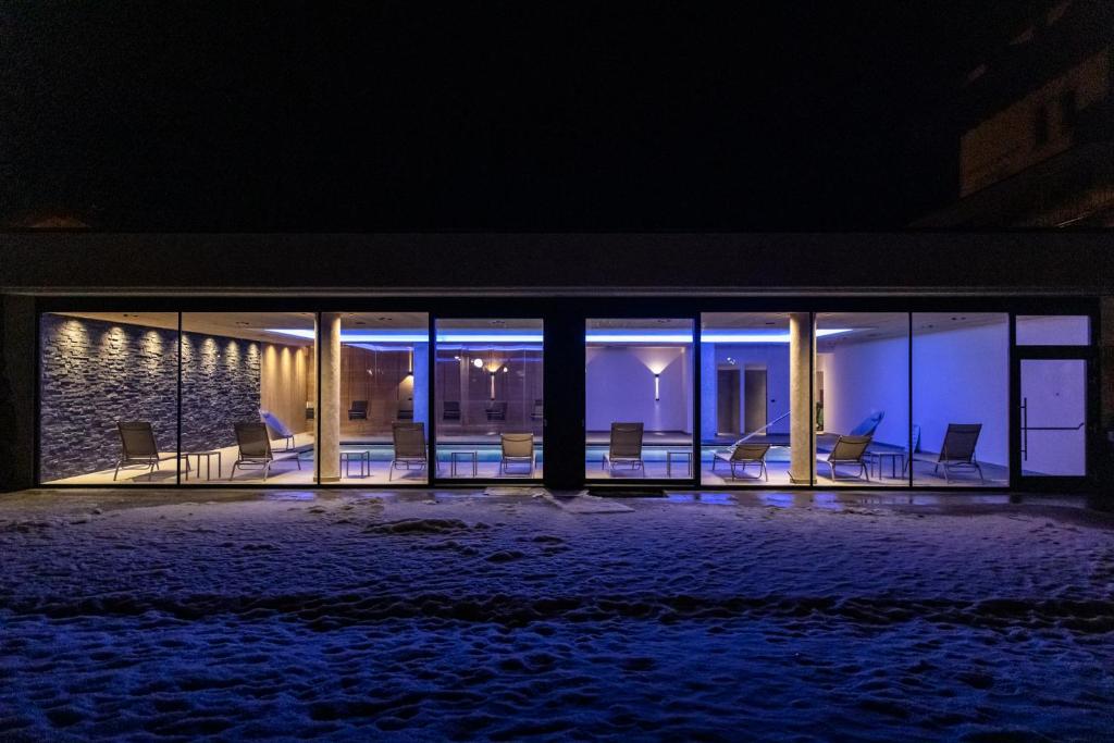 une maison avec une extension en verre la nuit dans l'établissement Monaco Sport Hotel, à Santo Stefano di Cadore