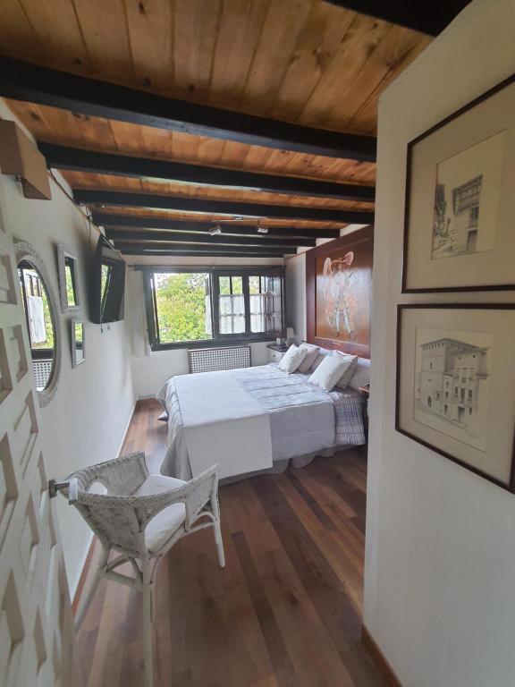 um quarto com uma cama e uma cadeira em El Arcángel de Santillana del Mar em Santillana del Mar