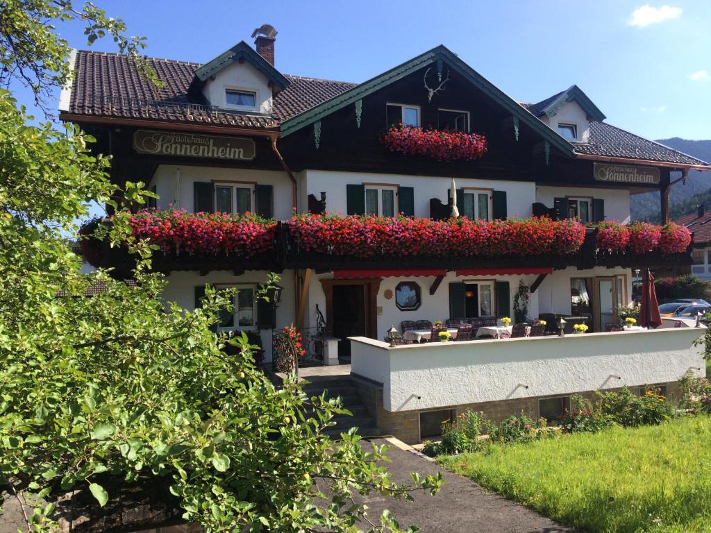 una casa con flores a un lado. en Gästehaus Sonnenheim, en Mittenwald