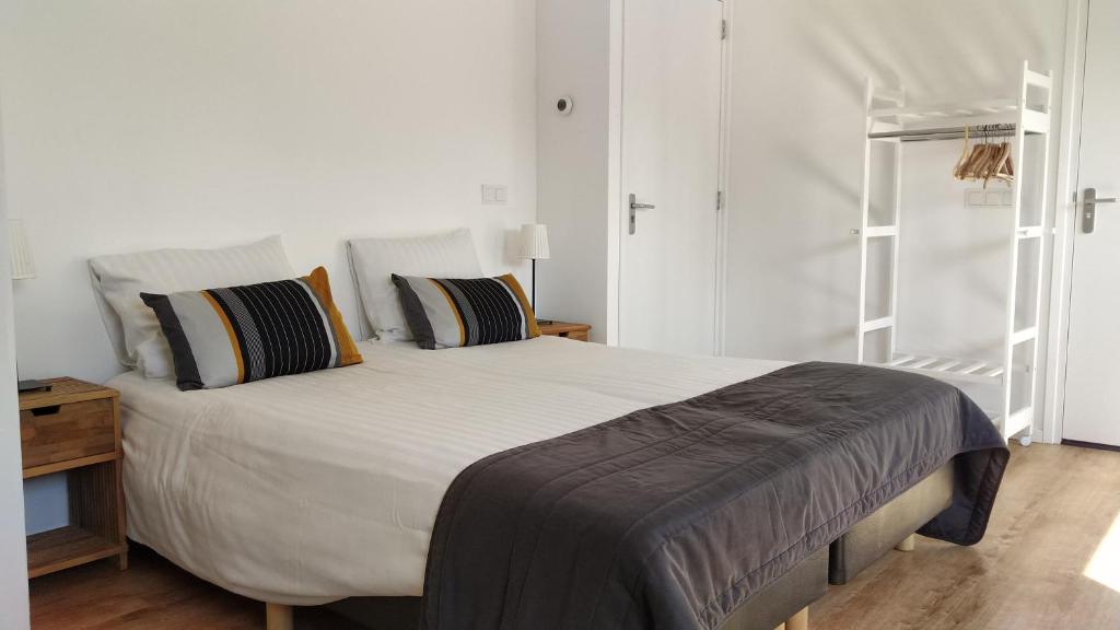 a bedroom with a large white bed with pillows at Studio@Domburg in Domburg