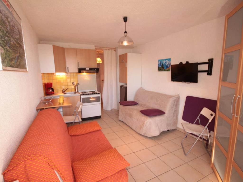 a living room with a couch and a kitchen at Studio Les Saisies, 1 pièce, 3 personnes - FR-1-293-3 in Les Saisies