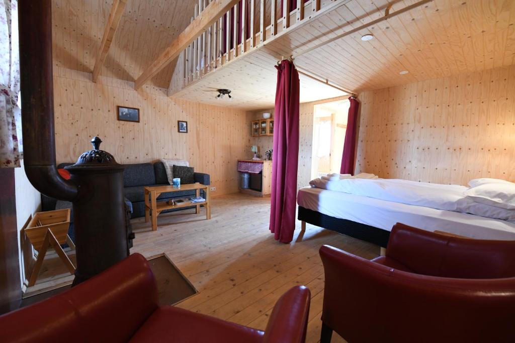a bedroom with a bed and a living room at Fjalladýrð Guesthouse in Modrudalur