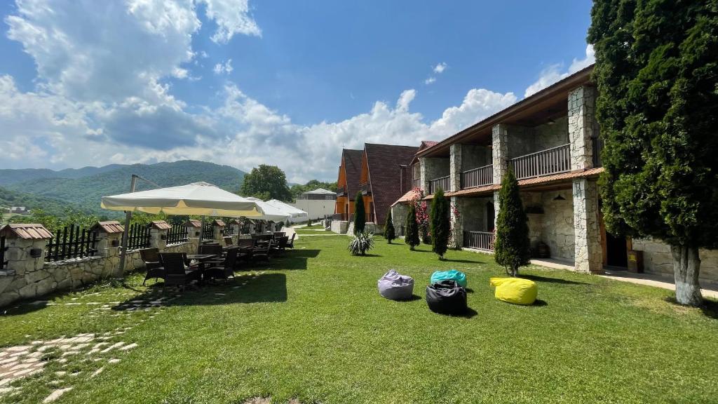 une cour avec des tables et des chaises et un bâtiment dans l'établissement Kirovi Tun, à Dilidjan