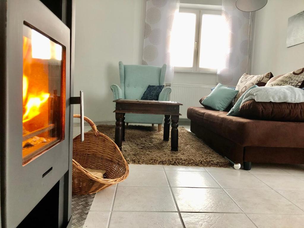 sala de estar con sofá, silla y chimenea en Ferienwohnung Mintbraun, en Waldkirchen