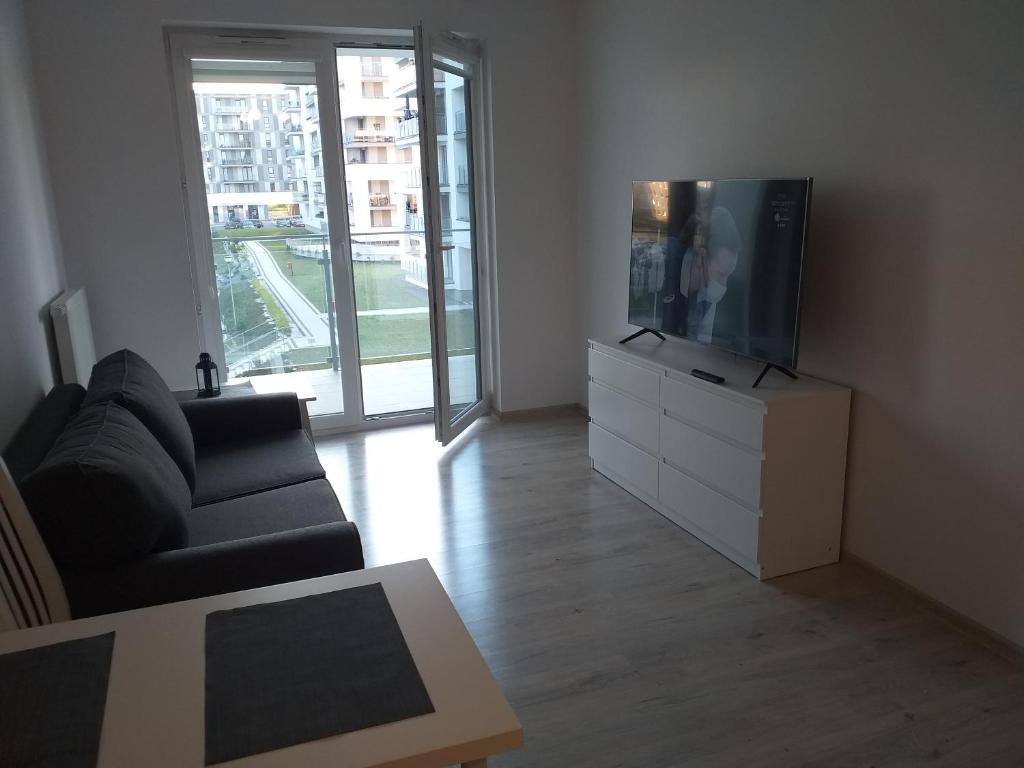 a living room with a couch and a flat screen tv at Apartament RUCZAJ in Lublin