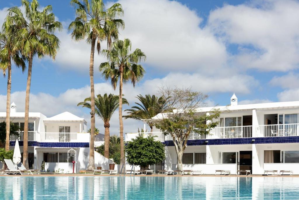 - Vistas a un complejo con palmeras y piscina en Barcarola Club, en Puerto del Carmen