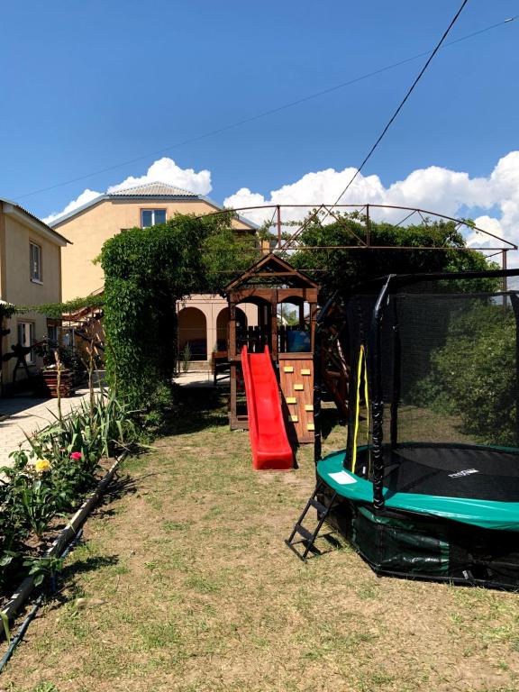 a backyard with a playground with a slide and a tv at Жар птиця in Zaliznyy Port