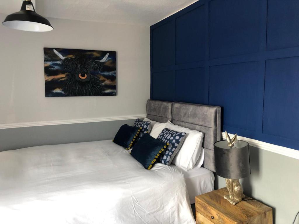 a bedroom with a bed with a blue accent wall at The Black Bull Inn in Middleham