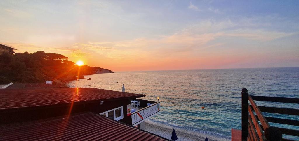 a view of the ocean with the sun setting over the ocean at Hotel Le Ghiaie in Portoferraio