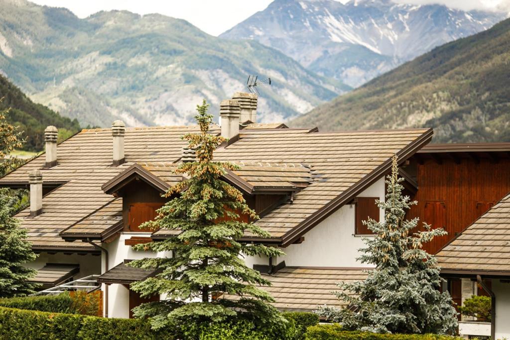 ウルクスにあるCasa montagna CIELO BLUの山を背景に屋根を持つ家