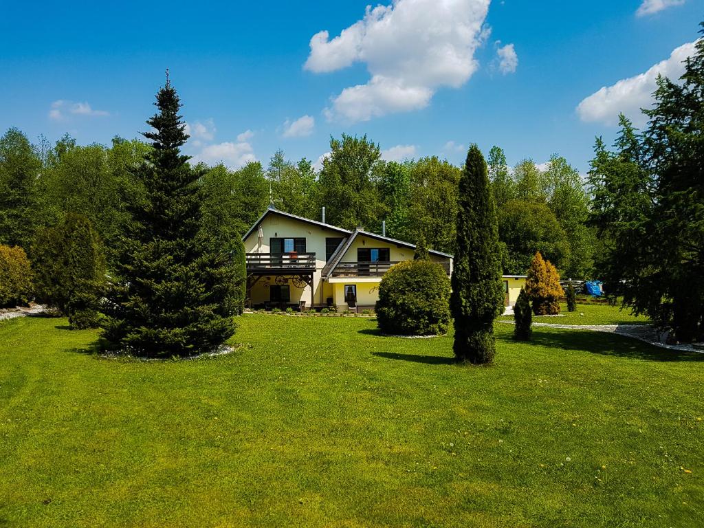 ein Haus inmitten eines Gartens mit Bäumen in der Unterkunft Apartmány LIZARD in Čeladná