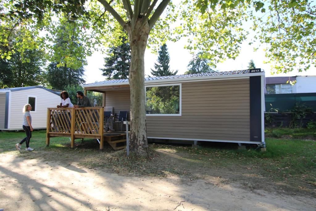 two people standing on the deck of a tiny house at Loggia Camping Belle-Vue 2000 in Berdorf